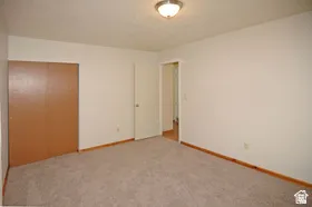 Carpeted room with light-toned walls and wood-finish baseboards