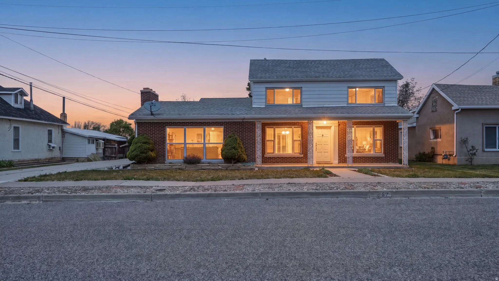 Brick and siding exterior featuring a covered front porch with white columns