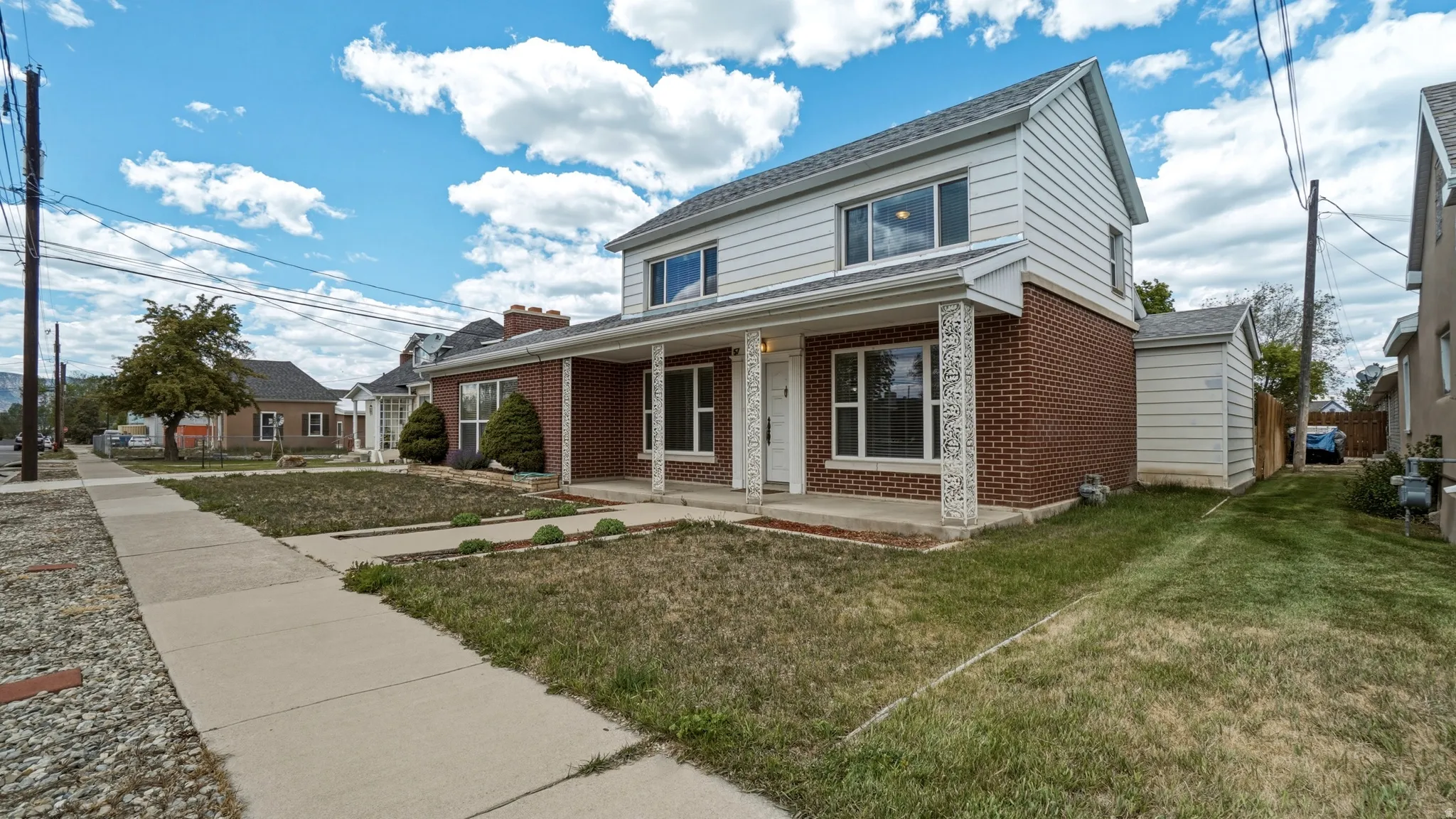 Two-story residence featuring brick and siding exterior with a covered front porch
