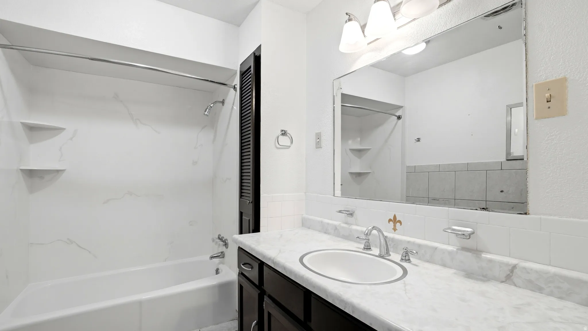 Bathroom featuring a dark wood-finish vanity with a white countertop and integrated sink