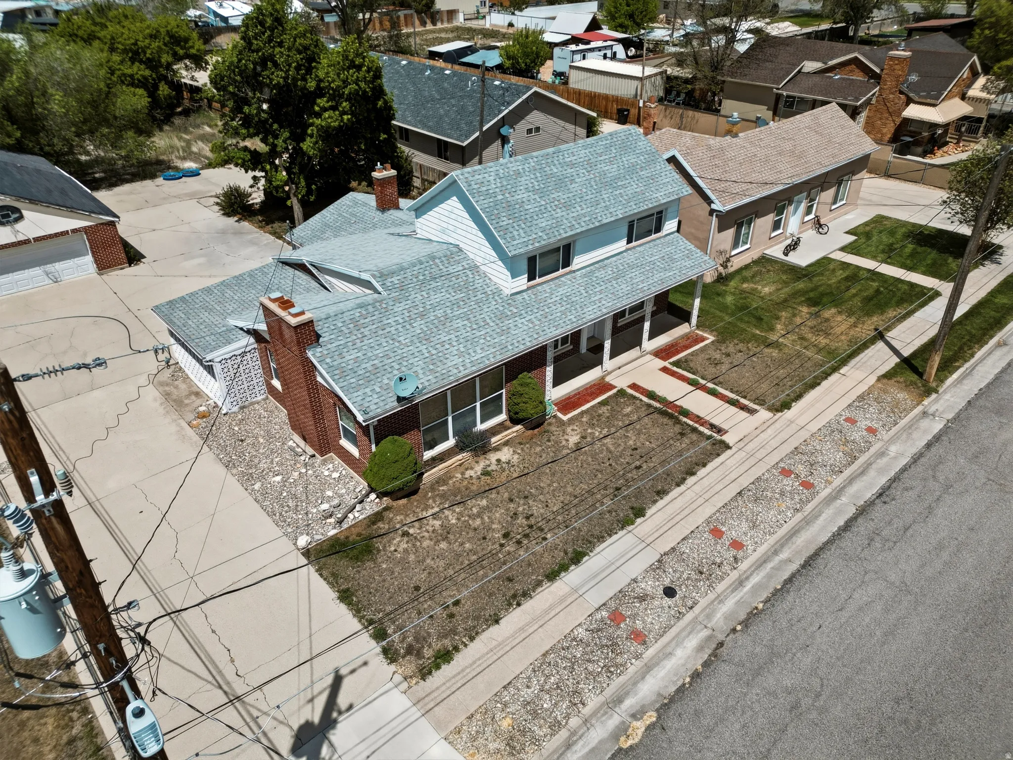 Two-story residence featuring a brick and light blue siding exterior, a covered front porch with white columns, and a light-colored shingle roof