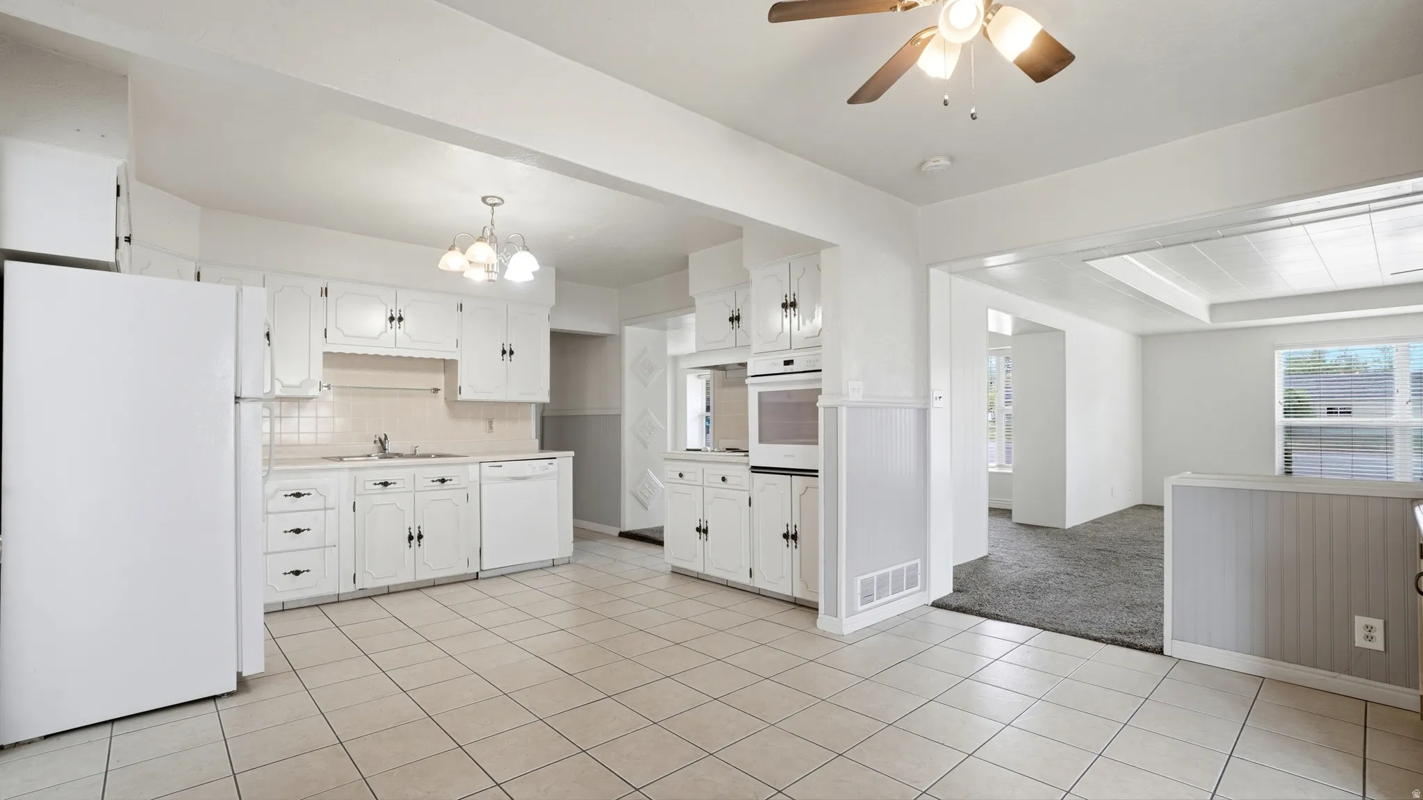 Kitchen featuring white cabinetry, tile flooring, built-in oven, and a ceiling fan