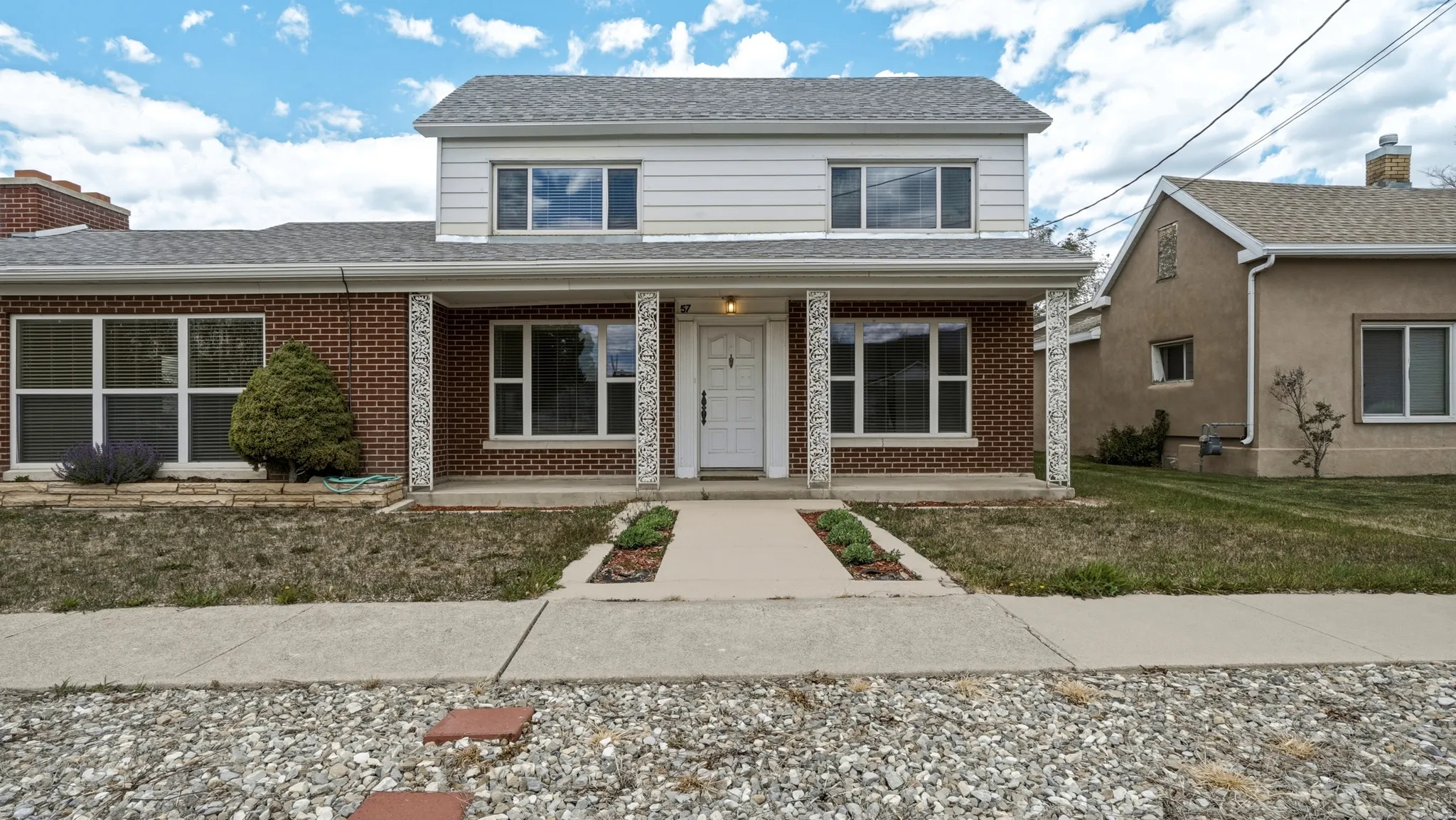Red brick and white siding exterior with a partial covered porch