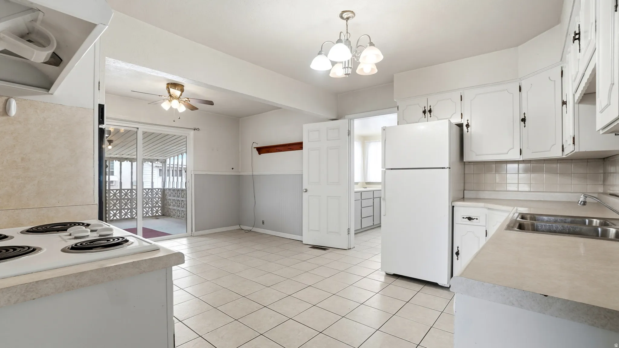 Kitchen featuring white cabinetry, tile flooring, and a sliding glass door to a screened porch