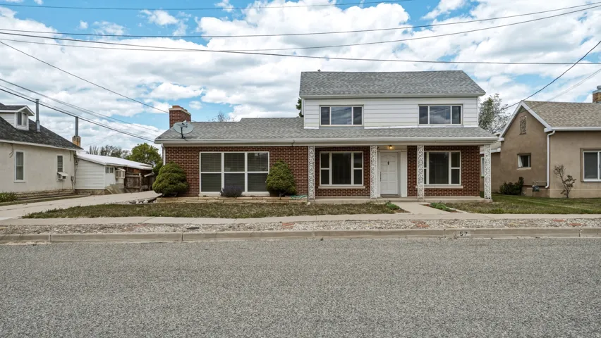Two-story residence featuring a brick first level and white siding on the second story