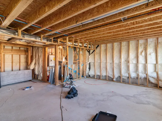 Unfinished basement with exposed wood framing, concrete flooring, and partial wall insulation