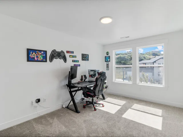 Bright room featuring two large windows, white walls, gray carpet, a flush-mount ceiling light, and white baseboards