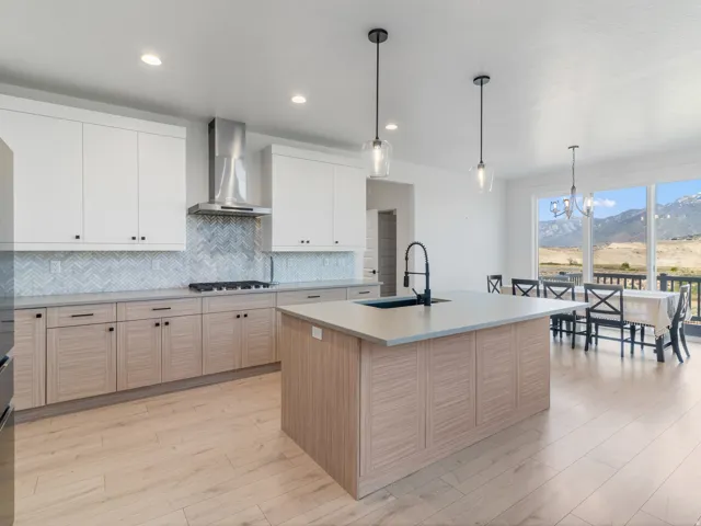 Contemporary kitchen with dual-tone cabinetry and a chevron tile backsplash