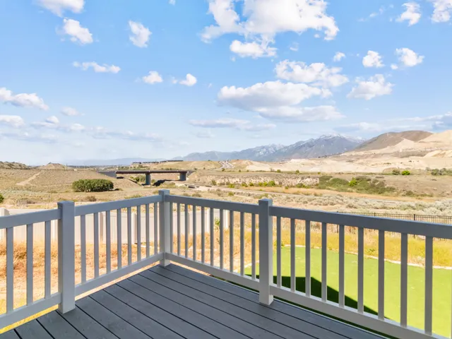 Outdoor deck with composite decking, white railing, and a distant mountain backdrop