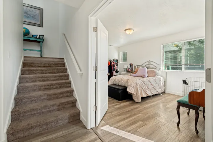 Spacious room with wood-finish flooring, white walls, and a large window