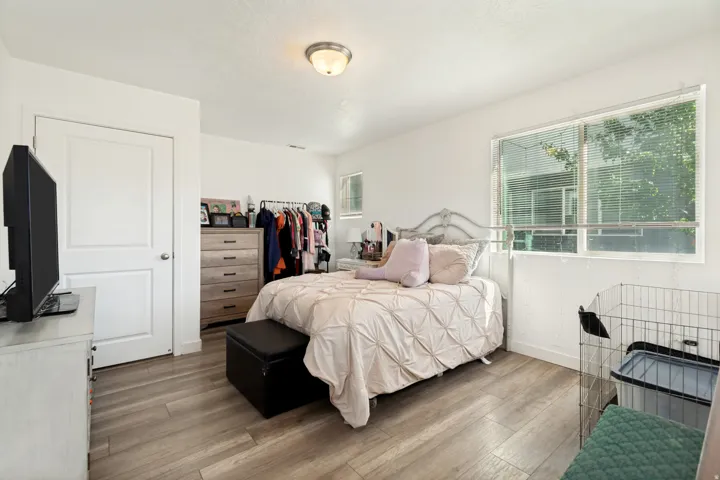 Bright room featuring wood-finish flooring and a large window with blinds
