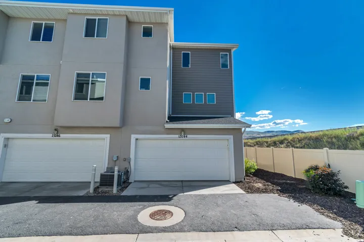 Contemporary multi-story exterior featuring a two-car garage, stucco and horizontal siding finishes, and multiple windows