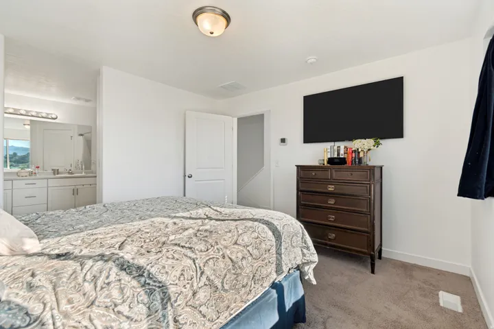 Plush gray carpeting and white walls define this bedroom space