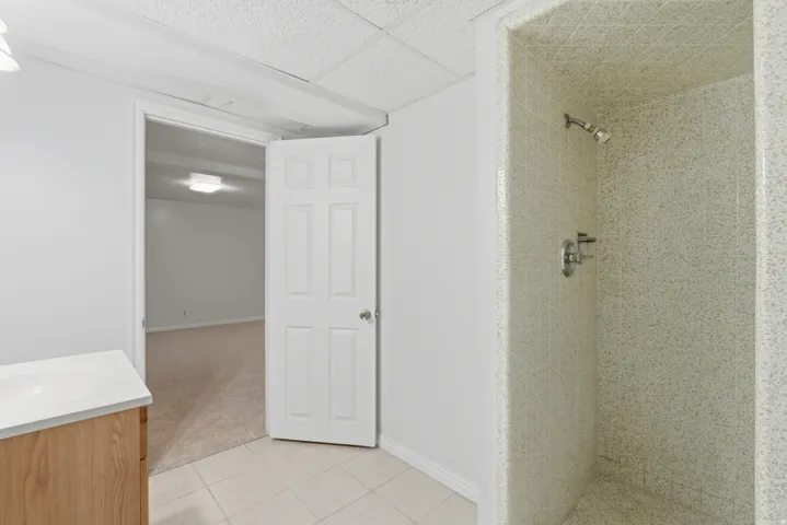 Tiled shower stall with a chrome showerhead and control