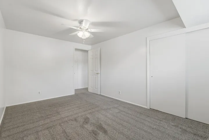 Neutral white walls and ceiling fan with light fixture