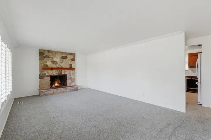 Living area featuring a floor-to-ceiling stone fireplace with a wood mantel