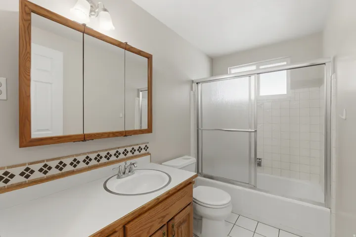 Bathroom vanity with an integrated sink, polished chrome faucet, and wood-finish cabinetry