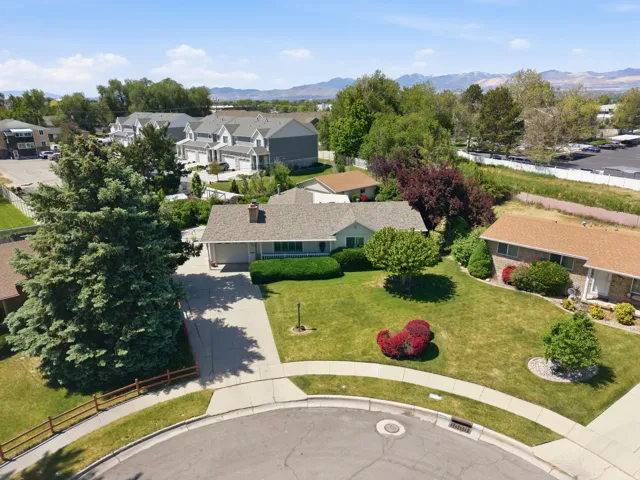 Single-story residence featuring a shingled roof, attached garage, and a concrete driveway