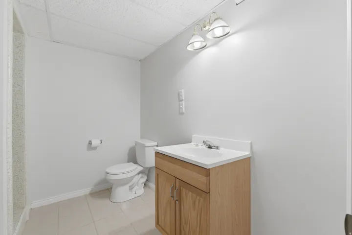 Bathroom featuring a wood-finish vanity with an integrated sink and chrome faucet
