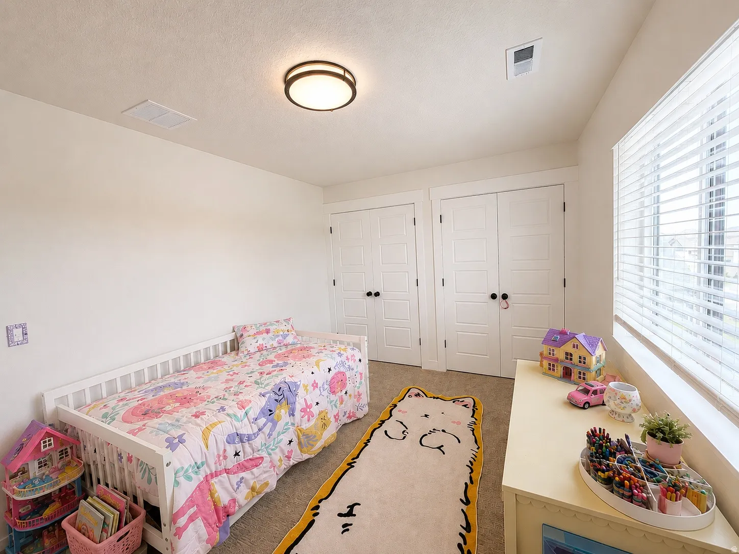 Room featuring light-colored walls, carpeted flooring, and two paneled doors with dark hardware