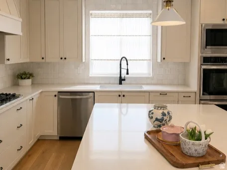 Kitchen featuring wood-finish flooring, recessed lighting, and a kitchen island with a light-toned countertop