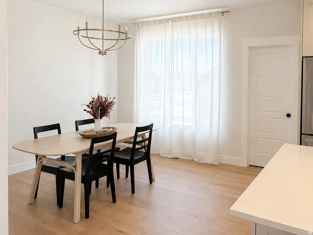 Dining area featuring light wood-finish flooring, a contemporary chandelier, recessed lighting, and sheer window treatments