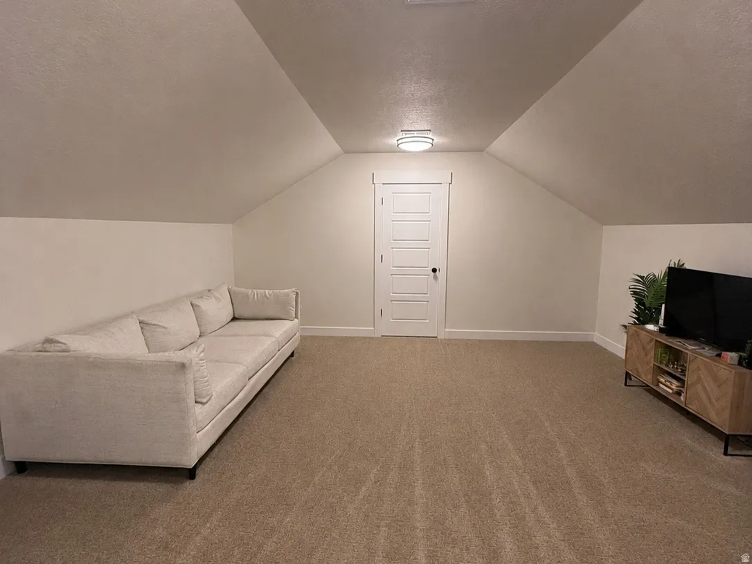 Primary bedroom sitting room featuring an angled ceiling design, two flush-mount ceiling lights, and a paneled interior door with trim