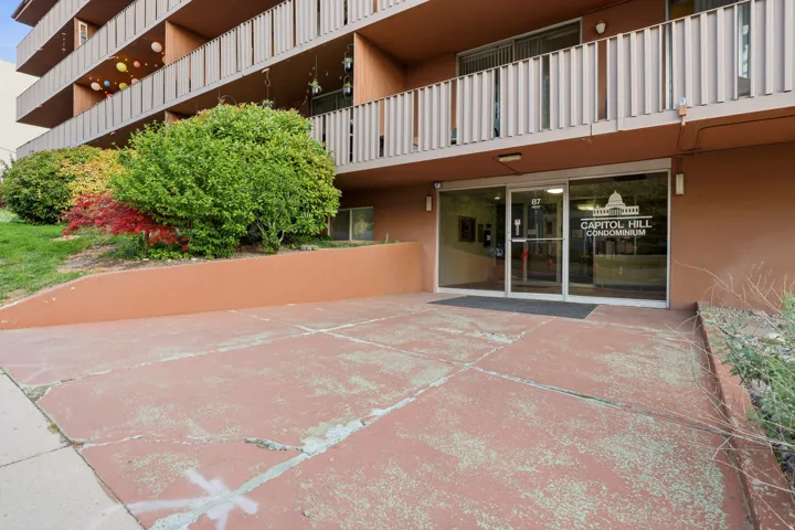 "Capitol Hill Condominium" building exterior featuring a ground-level entrance with glass doors