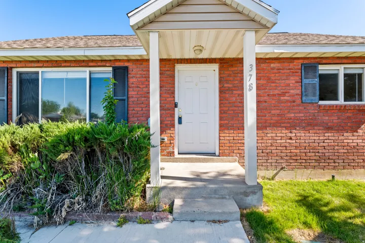 Brick exterior with white front door and covered entryway