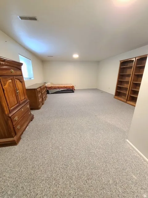 Spacious room with light-colored carpeting and white walls
