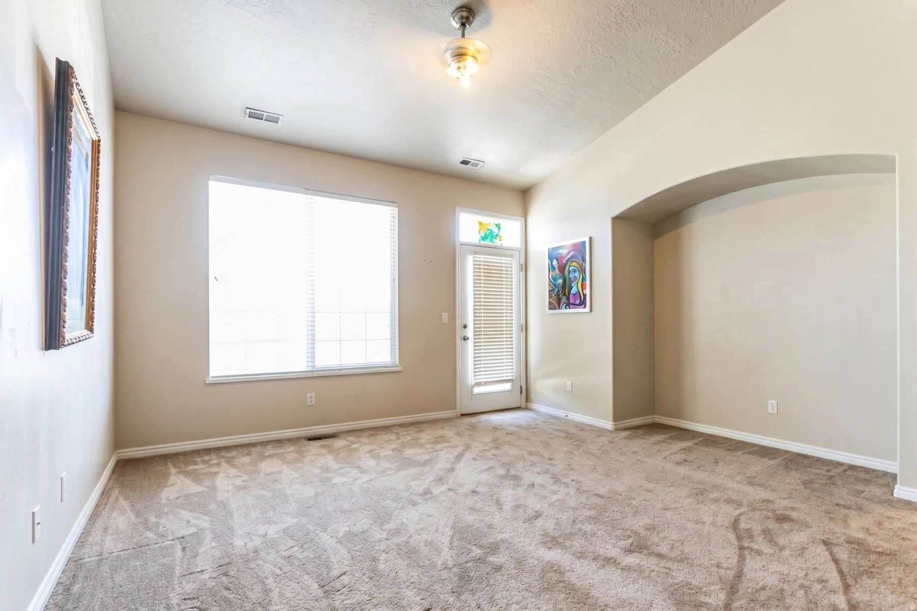 Furniture Removed by AI. Spacious room featuring neutral carpeting and light-colored walls