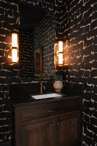 Vanity with dark wood cabinetry, integrated sink, and a dark countertop