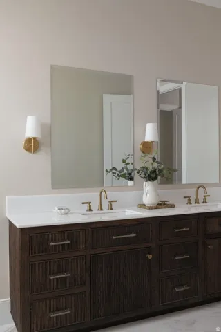 Double vanity featuring a white countertop with integrated sinks, brass-finish fixtures, and dark wood-finish cabinetry