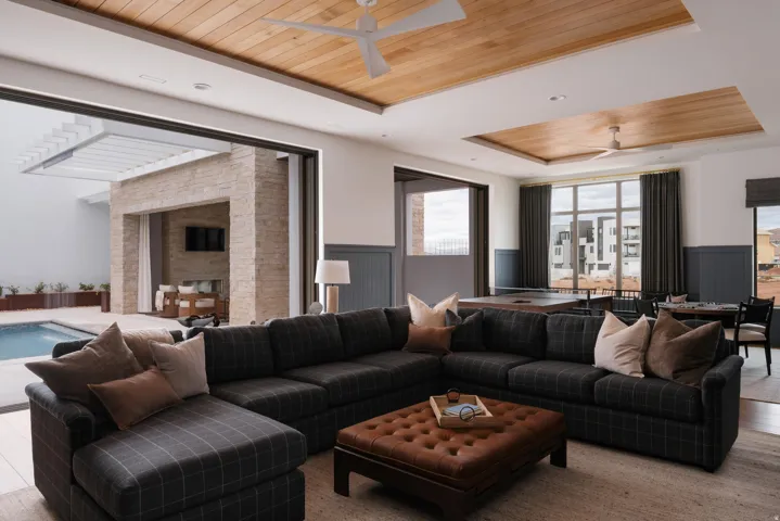 Expansive living area featuring large sliding glass doors opening to an outdoor patio with a swimming pool