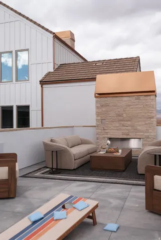 Rooftop patio with concrete flooring, a built-in stone fireplace, and a low privacy wall