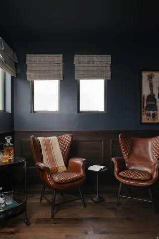 Rich wood-finish flooring complements dark wainscoting and deep-toned walls