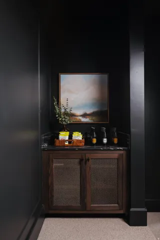 Custom built-in cabinetry featuring perforated metal door panels, a dark stone countertop, and a built-in backsplash