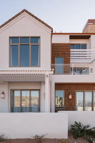 Multi-level exterior featuring white stucco, wood shake siding, and a tiled roof