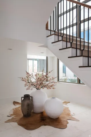 Staircase featuring dark wood treads, white risers, and black metal balusters with a wood handrail