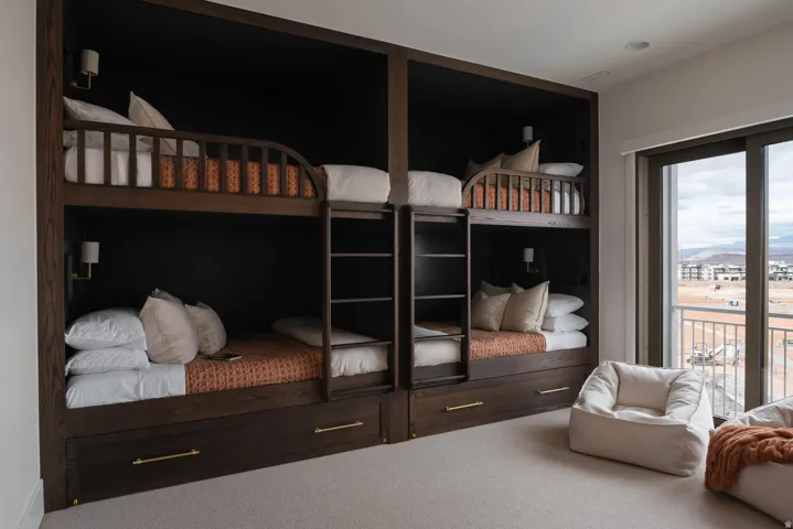 Built-in wood-finish bunk beds with integrated ladders and wall-mounted sconces