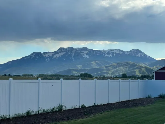Expansive mountain scenery featuring snow-capped peaks and verdant foothills