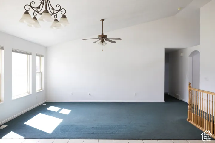 Vaulted ceilings featuring a chandelier and ceiling fan