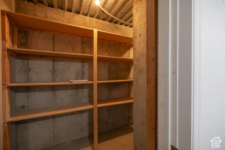 Built-in wood shelving units, concrete wall construction, and a white interior door