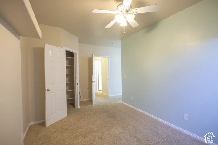 Wall-to-wall carpeting, recessed shelving, ceiling fan with integrated lighting, and neutral wall tones