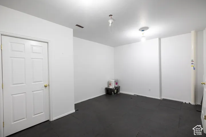 Spacious room with dark flooring, recessed ceiling lighting, and multiple entry points