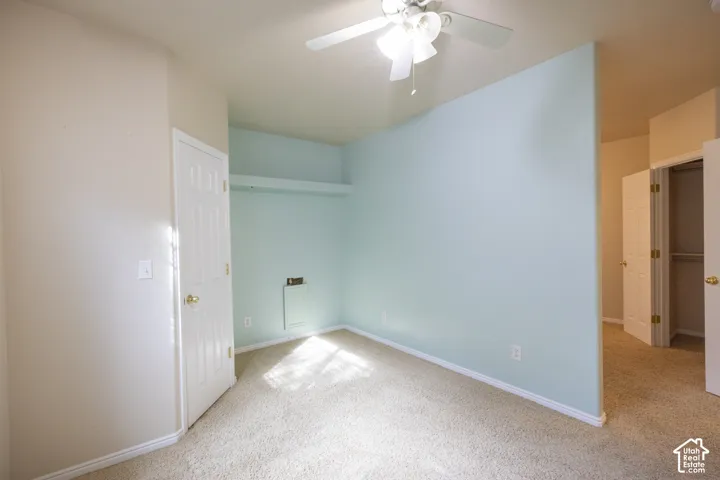 Recessed wall shelving, overhead ceiling fan, and carpeted flooring