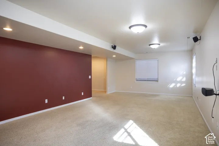 Carpeted flooring, recessed lighting, ceiling-mounted light fixtures, and windows with blinds