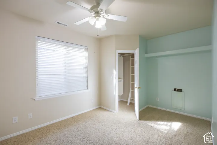 Recessed window with blinds, ceiling fan with integrated lighting, built-in shelving, carpeted flooring, and a closet with a built-in organizer