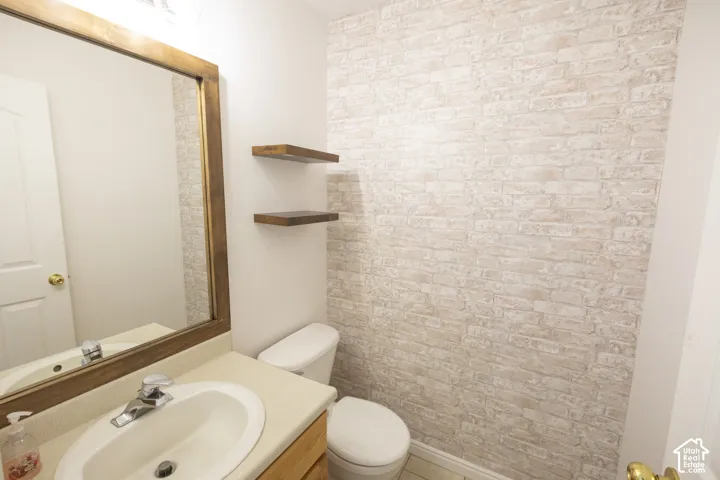 1/2 Bath, Vanity with an integrated sink, framed mirror, and two floating wood shelves