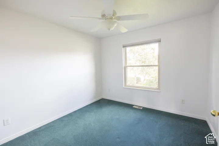 Room featuring wall-to-wall carpeting, ceiling fan, and a window with blinds
